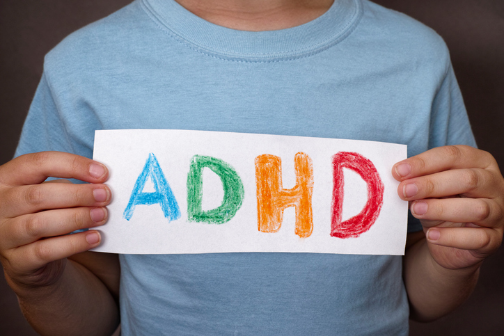 Deček drži znak z barvitim napisom ADHD